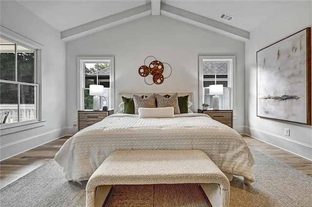 bedroom with hardwood / wood-style floors and vaulted ceiling with beams