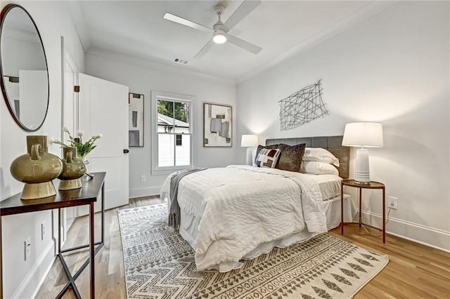 bedroom featuring light wood-type flooring, ceiling fan, and ornamental molding