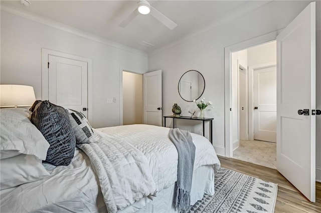 bedroom with light hardwood / wood-style floors, ceiling fan, and crown molding