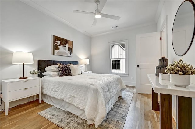 bedroom with ceiling fan, light hardwood / wood-style flooring, and crown molding