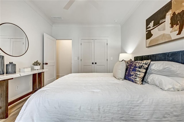 bedroom with crown molding, a closet, ceiling fan, and hardwood / wood-style flooring