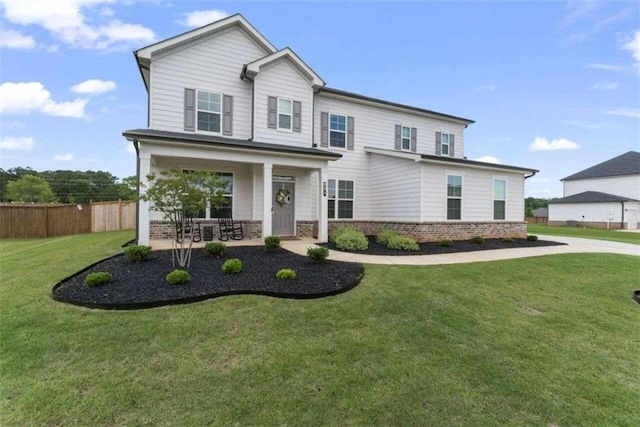 view of front of house with covered porch, brick siding, fence, and a front lawn