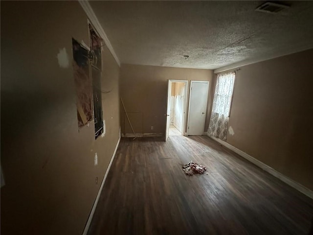 unfurnished room with a textured ceiling and dark hardwood / wood-style floors