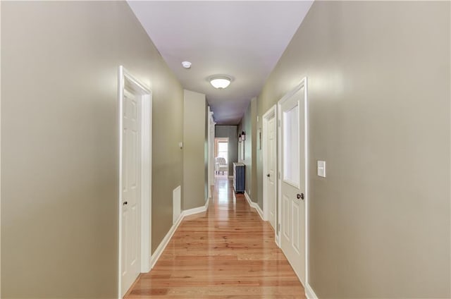 corridor with light hardwood / wood-style flooring