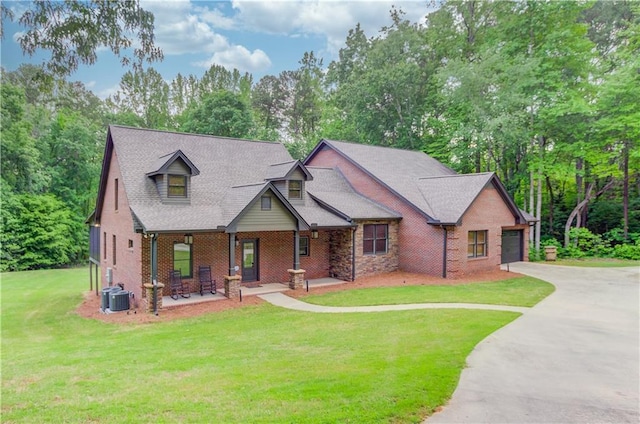 view of front facade with a porch, a garage, central AC, and a front lawn