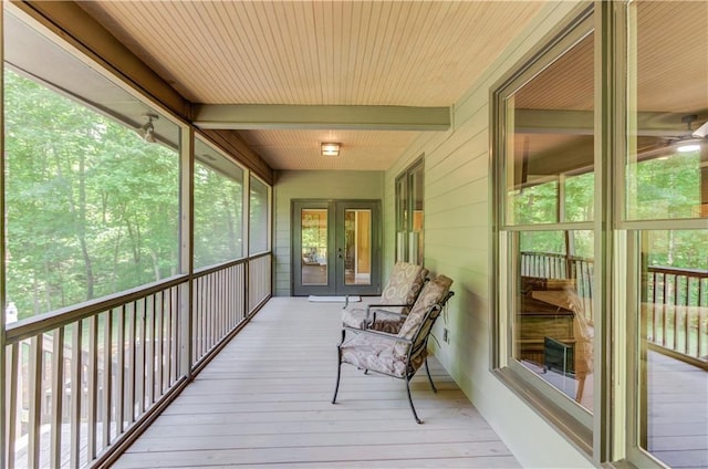 sunroom featuring beamed ceiling and french doors