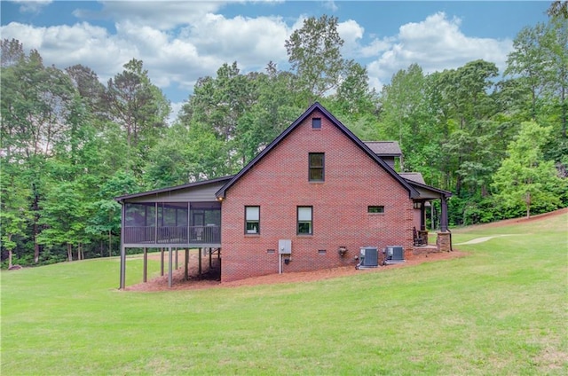 view of home's exterior featuring cooling unit, a yard, and a sunroom