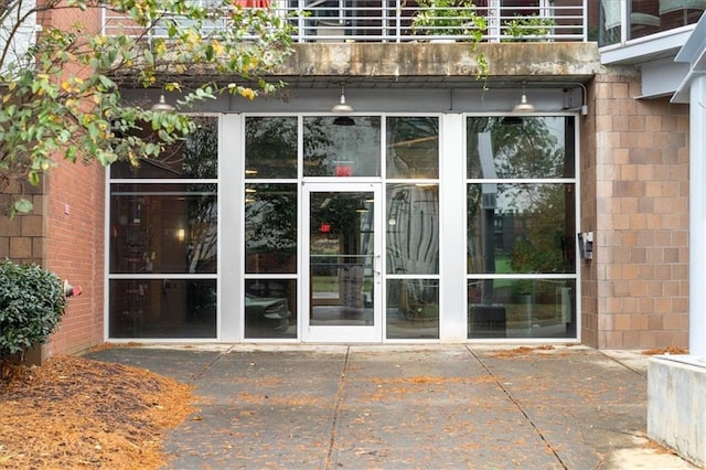 view of exterior entry featuring a balcony and a patio area