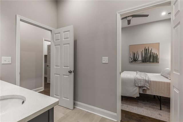 bathroom with wood-type flooring, vanity, and ceiling fan