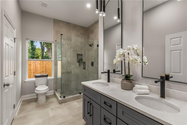 bathroom with a shower with door, tile patterned floors, vanity, and toilet