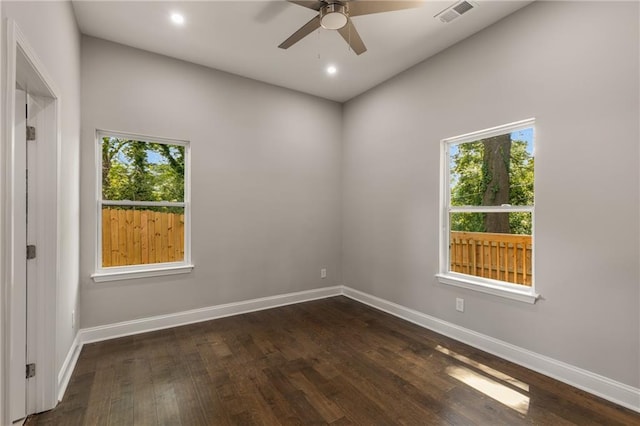 unfurnished room featuring ceiling fan, dark hardwood / wood-style flooring, and plenty of natural light