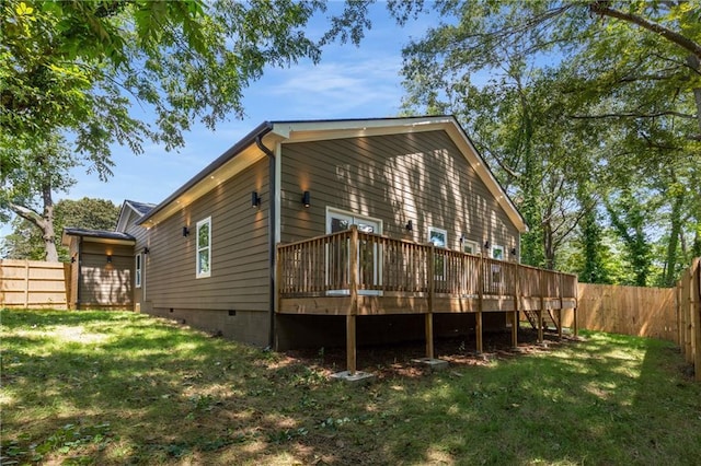 back of property featuring a lawn and a deck