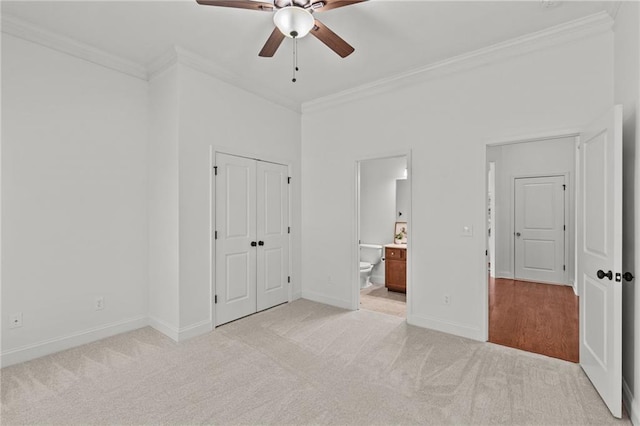 unfurnished bedroom with crown molding, light colored carpet, ensuite bathroom, and ceiling fan