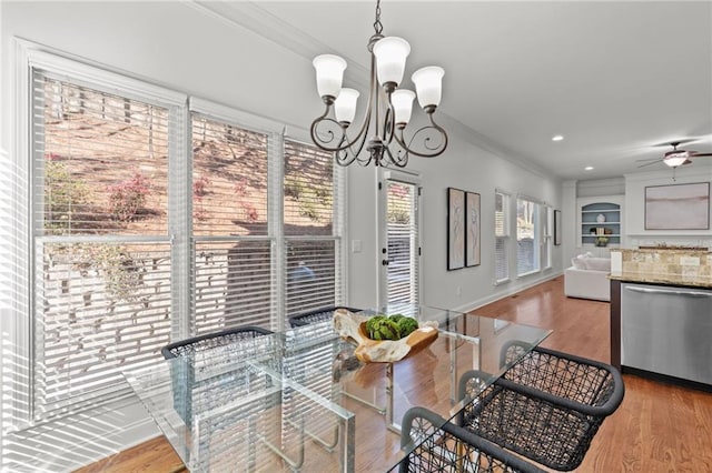 dining space featuring hardwood / wood-style flooring, ceiling fan with notable chandelier, and ornamental molding