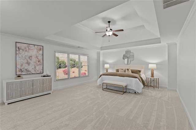 carpeted bedroom featuring a tray ceiling, ornamental molding, and ceiling fan