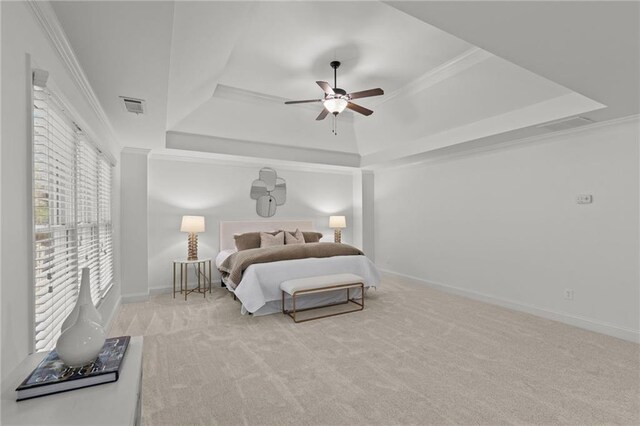 bedroom featuring ornamental molding, a raised ceiling, and light carpet