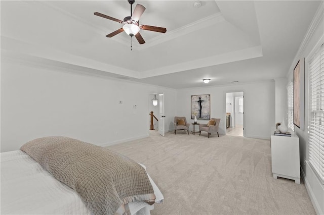 bedroom with ensuite bathroom, ornamental molding, light colored carpet, ceiling fan, and a raised ceiling