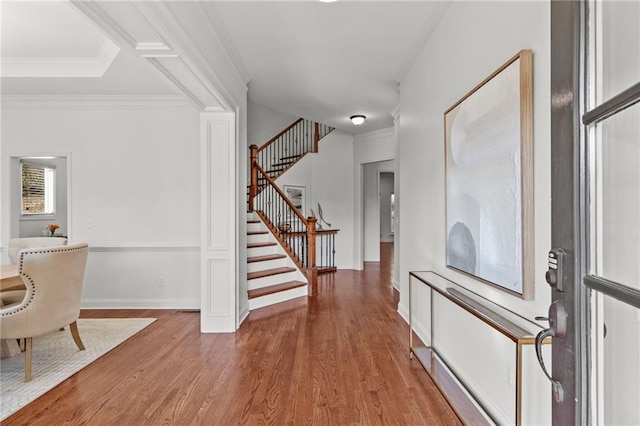 foyer with wood-type flooring and ornamental molding