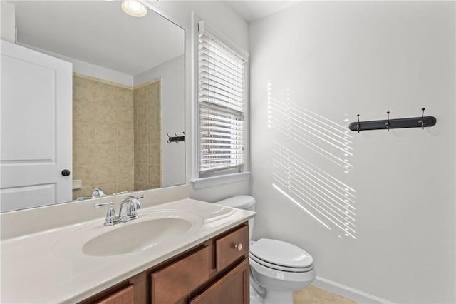 bathroom with plenty of natural light, toilet, and vanity