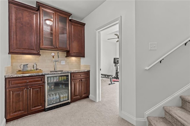 bar featuring tasteful backsplash, light stone countertops, light carpet, and wine cooler