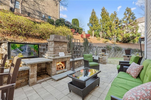 view of patio with an outdoor living space with a fireplace