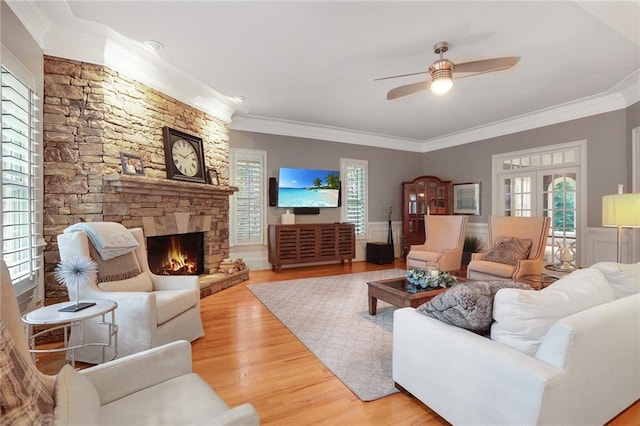 living room with a fireplace, hardwood / wood-style floors, ceiling fan, and ornamental molding