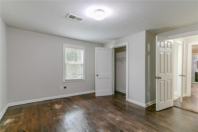 unfurnished bedroom featuring dark hardwood / wood-style flooring and a closet