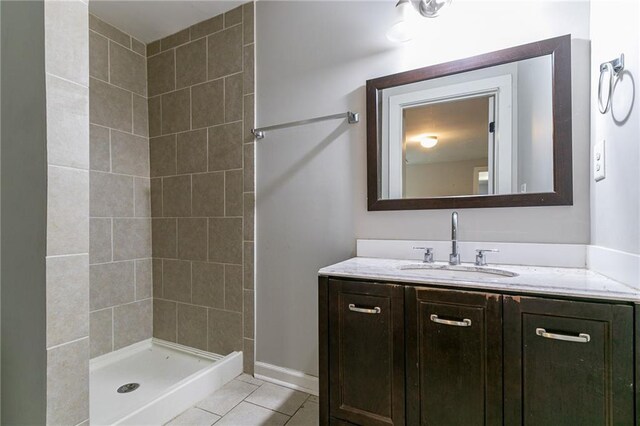 bathroom with tile patterned floors, vanity, and tiled shower