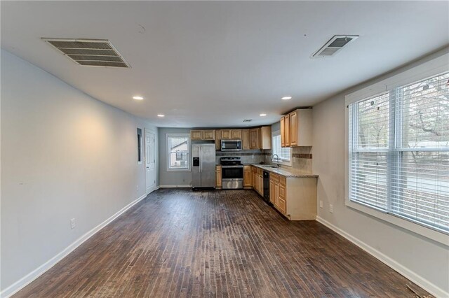 kitchen with light stone countertops, tasteful backsplash, stainless steel appliances, sink, and dark hardwood / wood-style floors