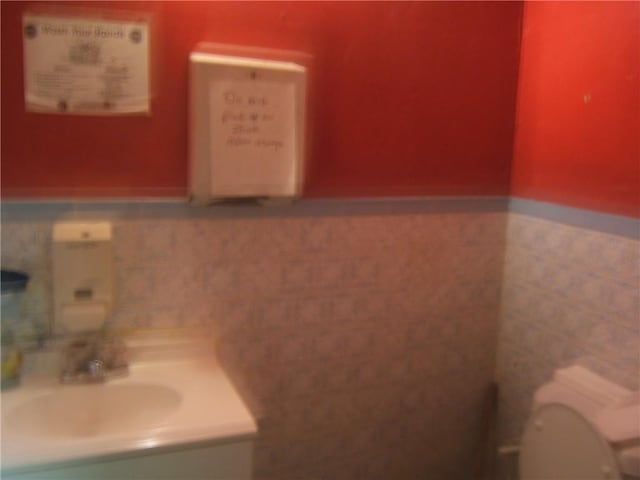 bathroom featuring tile walls, toilet, and vanity