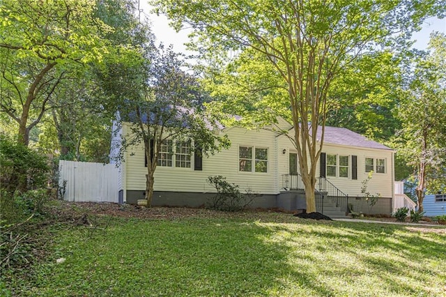 exterior space featuring crawl space, a front lawn, and fence