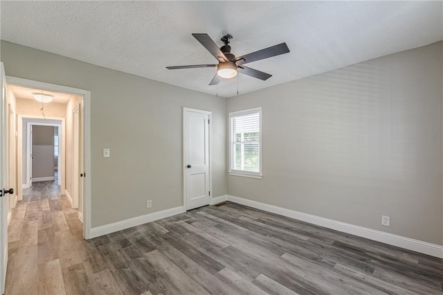 spare room with baseboards, a ceiling fan, and wood finished floors