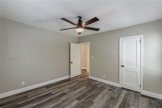 unfurnished bedroom featuring baseboards, wood finished floors, visible vents, and a textured ceiling