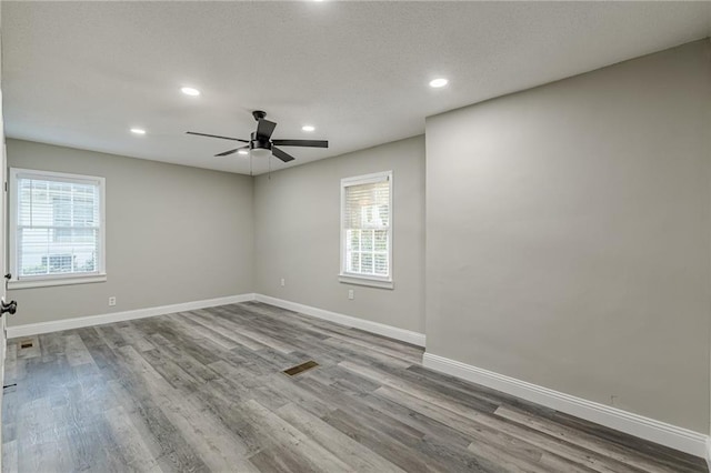 empty room featuring baseboards, a ceiling fan, wood finished floors, and recessed lighting