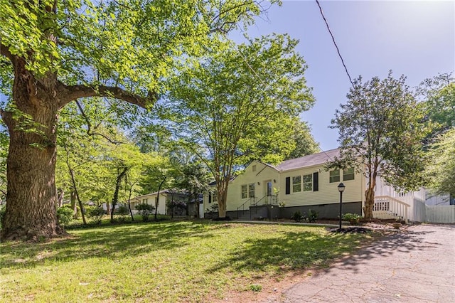 view of front of property with crawl space, a front yard, and fence