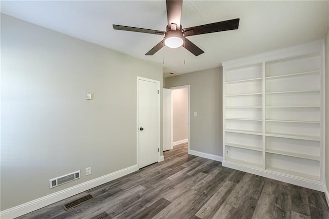 spare room featuring baseboards, wood finished floors, visible vents, and a ceiling fan