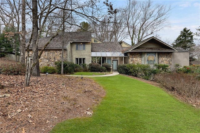 view of front facade with stone siding, stucco siding, and a front yard