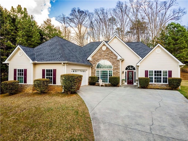 ranch-style home with an attached garage, stone siding, and a shingled roof