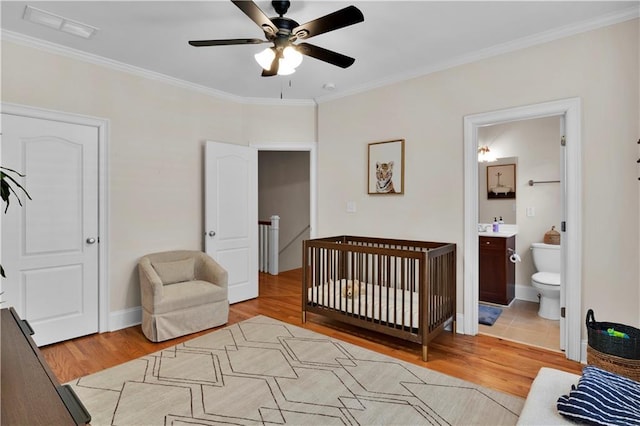 bedroom with baseboards, light wood finished floors, and crown molding