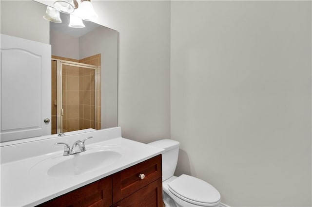 full bathroom featuring toilet, a shower stall, and vanity