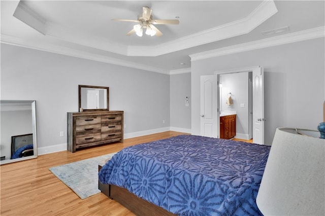 bedroom featuring ornamental molding, wood finished floors, a raised ceiling, and baseboards