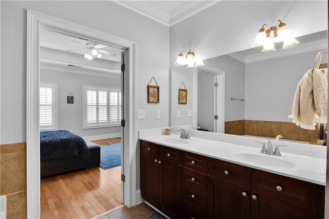 full bath featuring double vanity, a sink, and crown molding