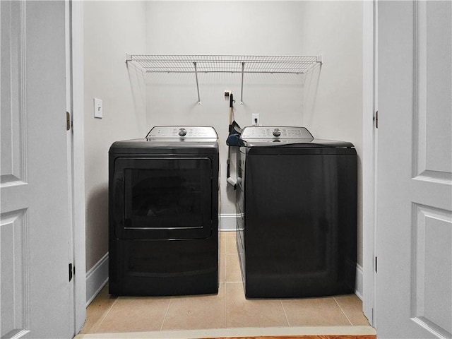 clothes washing area with light tile patterned floors, laundry area, and washing machine and dryer