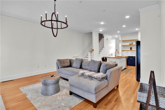 living area featuring ornamental molding, light wood-type flooring, stairway, and baseboards