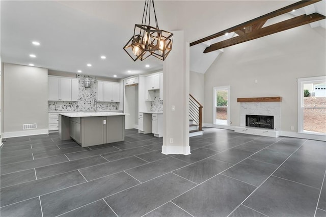 1066 Fairway Valley Dr, Woodstock, GA 30189 - kitchen with white cabinets, decorative backsplash, a fireplace, a kitchen island, and recessed lighting
