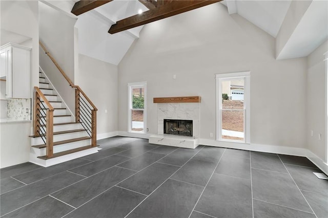 1066 Fairway Valley Dr, Woodstock, GA 30189 - unfurnished living room featuring high vaulted ceiling, dark tile patterned floors, beamed ceiling, stairway, and a high end fireplace