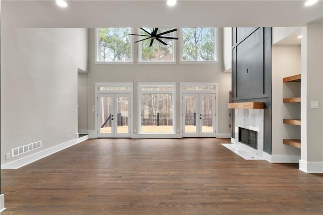 1066 Fairway Valley Dr, Woodstock, GA 30189 - unfurnished living room featuring french doors, a high end fireplace, a high ceiling, dark wood-style floors, and baseboards
