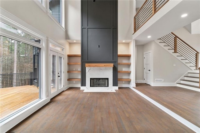 1066 Fairway Valley Dr, Woodstock, GA 30189 - unfurnished living room featuring a high ceiling, wood finished floors, stairs, baseboards, and a high end fireplace