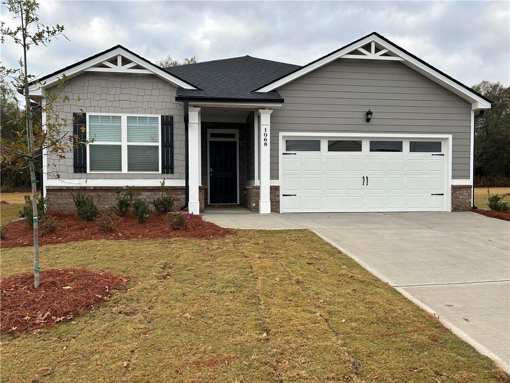 craftsman-style house with a garage and a front lawn