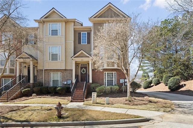 townhome / multi-family property with brick siding, board and batten siding, and concrete driveway